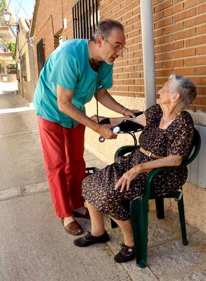 El médico Vicente Palomo toma la tensión a una vecina de Torrelaguna.