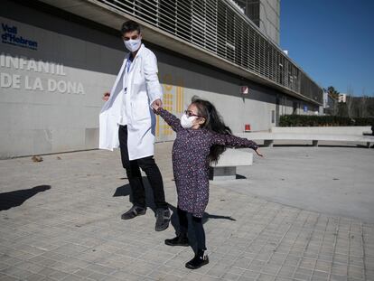 Margarida Fontes, de 9 años y recién sometida a un trasplante pulmonar, baila con su neumólogo, Nacho Iglesias, a las puertas del Hospital Vall d'Hebron de Barcelona.