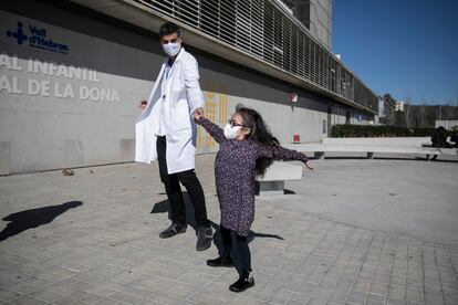 Margarida Fontes, de 9 años y recién sometida a un trasplante pulmonar, baila con su neumólogo, Nacho Iglesias, a las puertas del Hospital Vall d'Hebron de Barcelona.