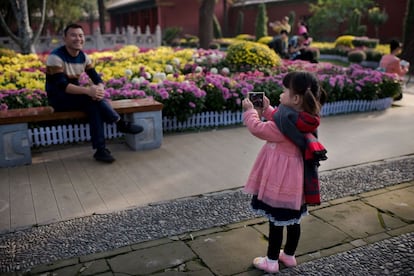 Una niña saca una foto de su padre en la Ciudad Prohibida de Pekín (China). 