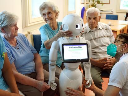 Un grupo de ancianos utiliza un robot auxiliar con inteligencia artificial.