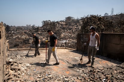 Young people work with shovels to remove debris from a house.