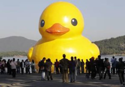 Turistas observan un pato gigante amarillo instalado el pasado 26 de septiembre de 2013 en el lago cerca del Palacio de Verano en Pekn (China). La instalacin de 18 metros, creada por el artista holands Florentijn Hofman. EFE/Archivo