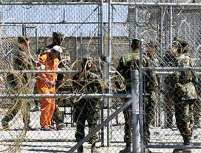 Policías militares conducen a un talibán para ser interrogado en la base estadounidense de Guantánamo (Cuba).