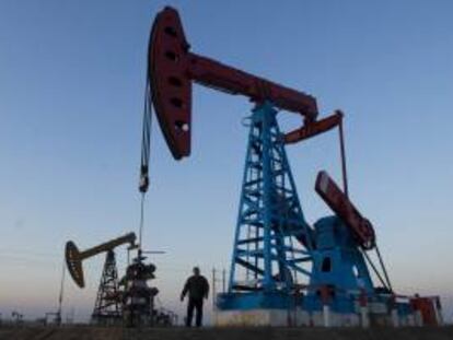 Un trabajador bajo un pozo de petróleo inspecciona el equipamiento de bompeo del crudo en la explotación petrolífera de Gudong, en China. EFE/Archivo