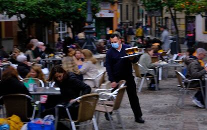 Un camarero atiende varias mesas en Sevilla.