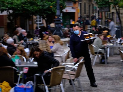 Un camarero atiende varias mesas en Sevilla.
