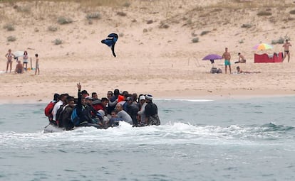 Migrantes saludan desde la embarcación en la que han cruzado el Estrecho hasta Tarifa, el 27 de julio.