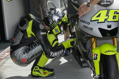 El piloto italiano de Yamaha, Valentino Rossi, inspecciona su moto antes de comenzar su entrenamiento en el circuito de Sepang.