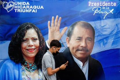 Um homem caminha diante de um cartaz de propaganda que mostra o presidente da Nicarágua, Daniel Ortega, e a recém-nomeada ‘copresidenta’ Rosario Murillo.