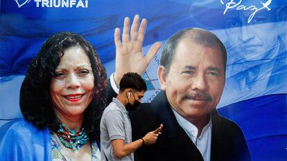 Um homem caminha diante de um cartaz de propaganda que mostra o presidente da Nicarágua, Daniel Ortega, e a recém-nomeada ‘copresidenta’ Rosario Murillo.