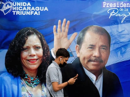 Um homem caminha diante de um cartaz de propaganda que mostra o presidente da Nicarágua, Daniel Ortega, e a recém-nomeada ‘copresidenta’ Rosario Murillo.