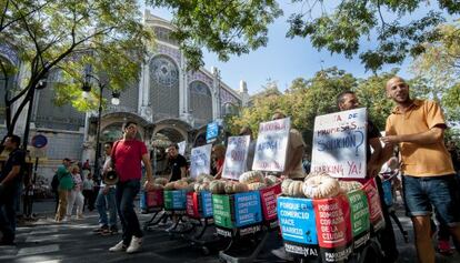 Vendedores del Mercat Central con carros cargados de calabazas por el bloqueo del aparcamiento.