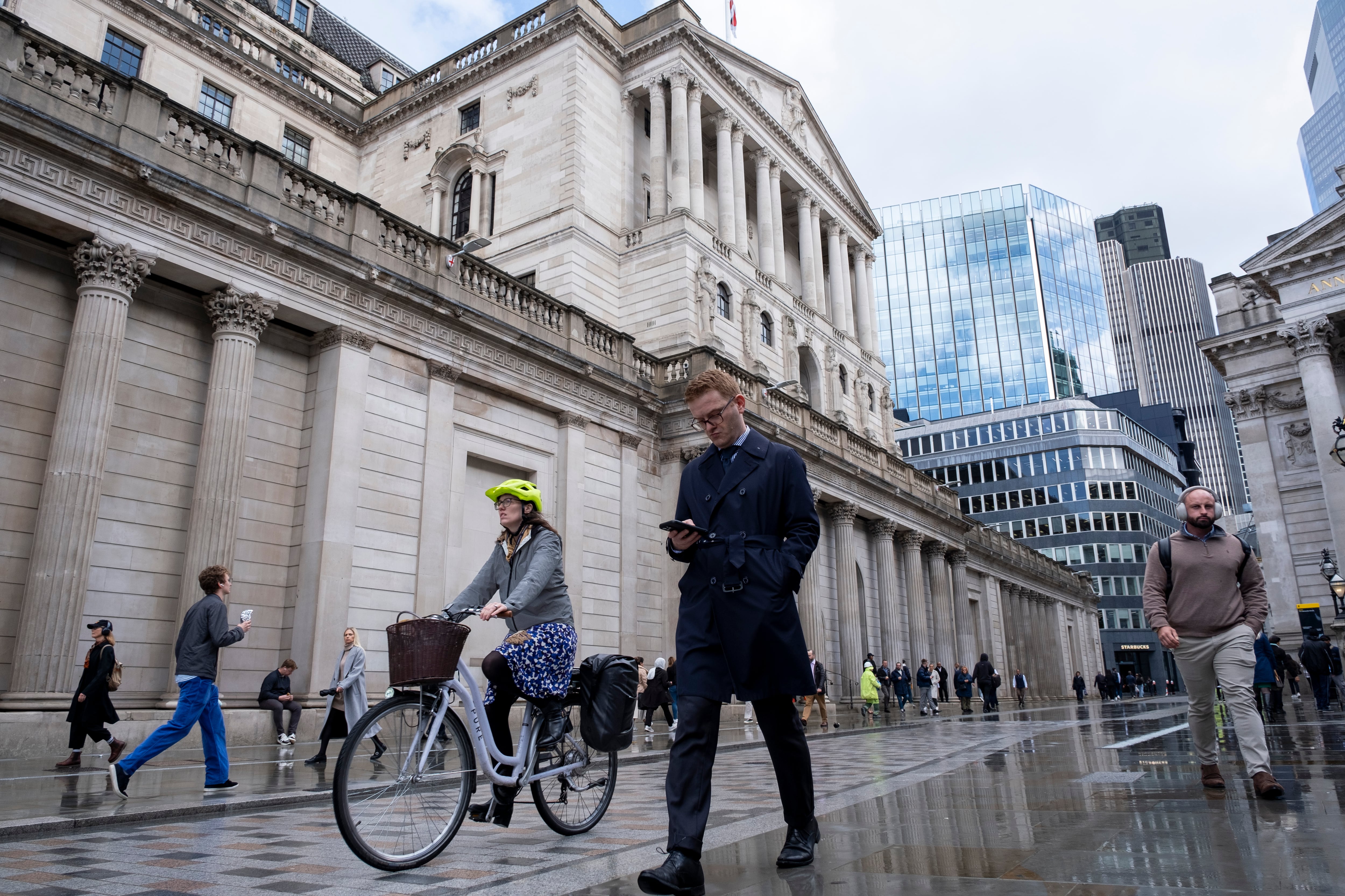 Peatones y ciclistas caminan delante del Banco de Inglaterra, en el corazón del distrito financiero de Londres.