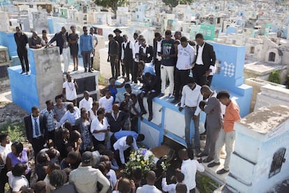 Un grupo de familiares y amigos observan como un pariente fallecido es enterrado en el cementerio nacional de Puerto Príncipe, en Haití. Mientras que muchos haitianos unen recursos y buscan ayuda en familiares que vivan en el extranjero para pagar los gastos funerarios, muchas familias se ven obligadas a vender sus posesiones o a solicitar préstamos con intereses muy altos para costearlos.