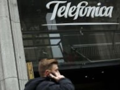 Un usuario habla por el m&oacute;vil junto a la sede de Telef&oacute;nica en Gran V&iacute;a.