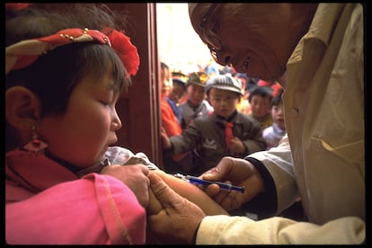 Un trabajador de la salud vacuna a una niña en una clínica del Fondo de las Naciones Unidas para la Infancia (Unicef) en la localidad de Shia Huang Lou, en la provincia china de Shanxi, en 1993. En un contexto mundial en el que aumenta la desconfianza acerca de las vacunas, el gigante asiático es una excepción, junto a países como India o México, según Unicef. El 95% de la población consideraba en 2022 que la inmunización infantil es importante. Del total de 55 países estudiados, en 52 disminuyó la confianza en las vacunas tras la pandemia de covid. 
