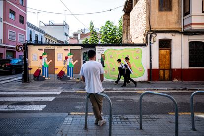 El artista urbano J. Warx, frente a uno de sus murales en el barrio de Benimaclet, en Valencia este miércoles.