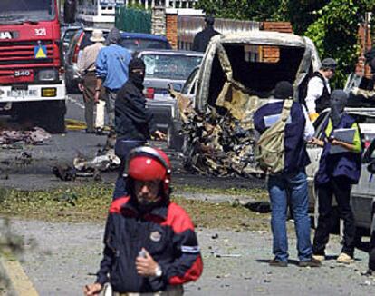 La policía vasca examina el lugar donde la banda terrorista ETA explosionó ayer un coche bomba.