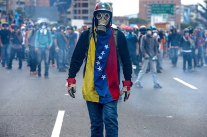 Venezuela vive desde el 1 de abril una ola de manifestaciones a favor y en contra del Gobierno, algunas de las cuales se han tornado violentas con un saldo de 37 muertos y centenares de heridos. En la imagen, un joven con máscara antigas y bandera de Venezuela, en un momento de la manifestación.