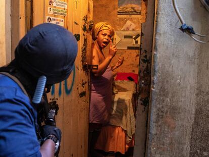 Una mujer reacciona después de que un policía irrumpiera en su habitación.