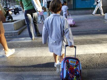 Un niño arrastra su mochila, camino de su centro escolar en Madrid.