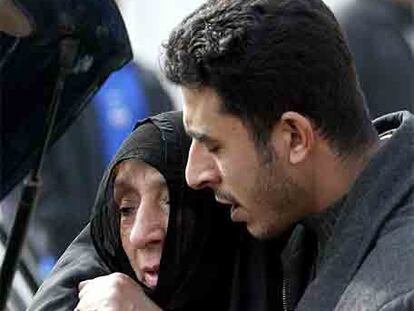 Un joven iraquí consuela a la madre de la víctima de un atentado ocurrido en Bagdad el pasado miércoles.