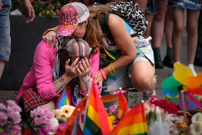 Un hombre llora frente a la ofrenda floral.