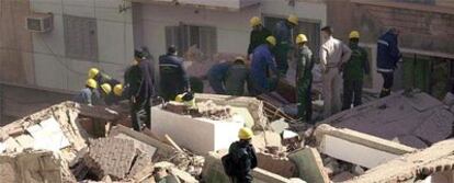 Bomberos y trabajadores de emergencia, sobre los escombros del edificio siniestrado.