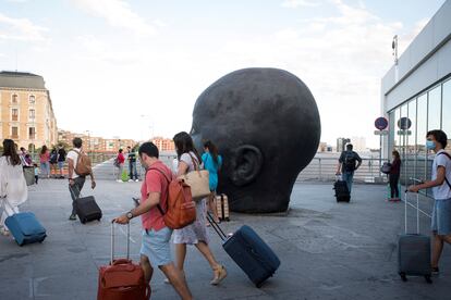 Los viajeros veraniegos llegan a la estación de Atocha.