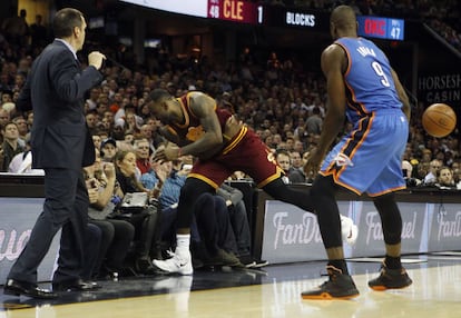 James LeBron de los Cleveland intenta salvar un balón en la segunda mitad del partido disputado contra los Thunder de Oklahoma y cae sobre los espectadores, provocando lesiones a la mujer del golfista Jason Day, Ellie Day, que tuvo que ser trasladada al hospital, en el Quicken Loans Arena de Cleveland.