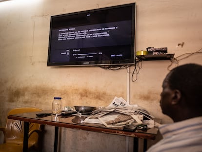 Un hombre observa un televisor que muestra la señal cortada del canal France24, horas después de que la junta gobernante en Burkina Faso decidiera suspender el canal, en Uagadugú, el 27 de marzo de 2023.