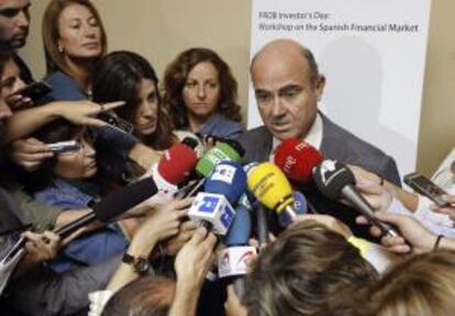 El ministro de Economía, Luis de Guindos, atiende a los medios tras clausurar una jornada de trabajo organizada por el Fondo de Reestructuración Ordenada Bancaria (FROB) sobre el sistema financiero español, dirigida a inversores internacionales que se ha celebrado hoy en Madrid.