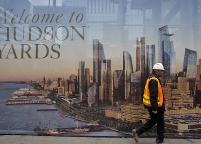 Un trabajador de la construcción pasa por delante de un cartel promocional del nuevo barrio neoyorkino de Hudson Yards. |