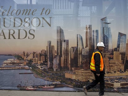 Un trabajador de la construcción pasa por delante de un cartel promocional del nuevo barrio neoyorkino de Hudson Yards. |