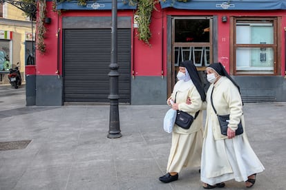 Dos monjas pasan por un restaurante cerrado en el distrito de La Latina, en Madrid, el 1 de febrero de 2021.