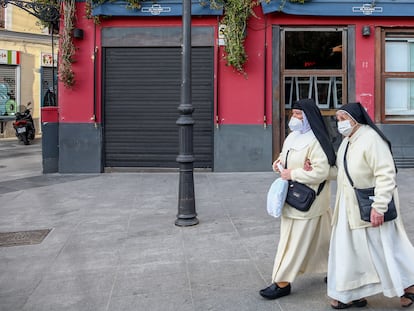 Dos monjas pasan por un restaurante cerrado en el distrito de La Latina, en Madrid, el 1 de febrero de 2021.