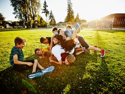 Un grupo de niños y niñas juegan juntos en un parque.