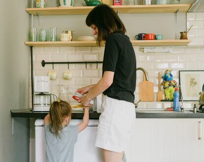 Una madre prepara la merienda con su pequeña.