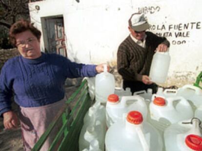 Un matrimonio carga garrafas de agua en un carromato, en la fuente del Mojón de Albox.