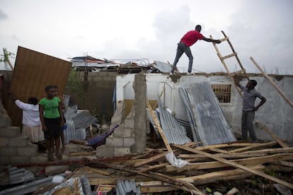 Dos home intenten reparar les seves llars destruïdes després del pas de l'huracà en Les Cayes, Haití.