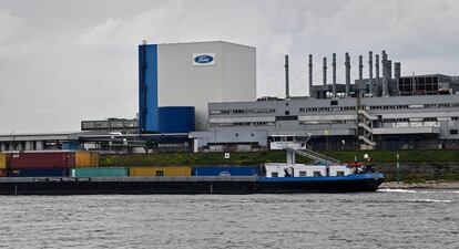 FILE - A container ship passes the Ford car plant in Cologne, Germany, May 4, 2020. Ford said that it will cut 3,800 jobs in Europe over the next three years in an effort to streamline its operations as it contends with economic headwinds and increasing competition on electric cars. The automaker said that 2,300 jobs will go in Germany. (AP Photo/Martin Meissner, File)