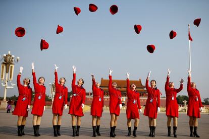 Un grupo de acomodadoras lanza al aire sus sombreros mientras posan para una fotografía en la plaza de Tiananmen, antes del comienzo de la sesión de clausura del XIX Congreso Nacional del Partido Comunista Chino, en Pekín (China).