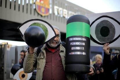 Un manifestante sujeta una pancarta con un ojo y una bala en una protesta convocada por Tsunami Democràtic, cerca del Camp Nou con motivo del partido que disputarán el Barcelona y el Real Madrid esta noche.