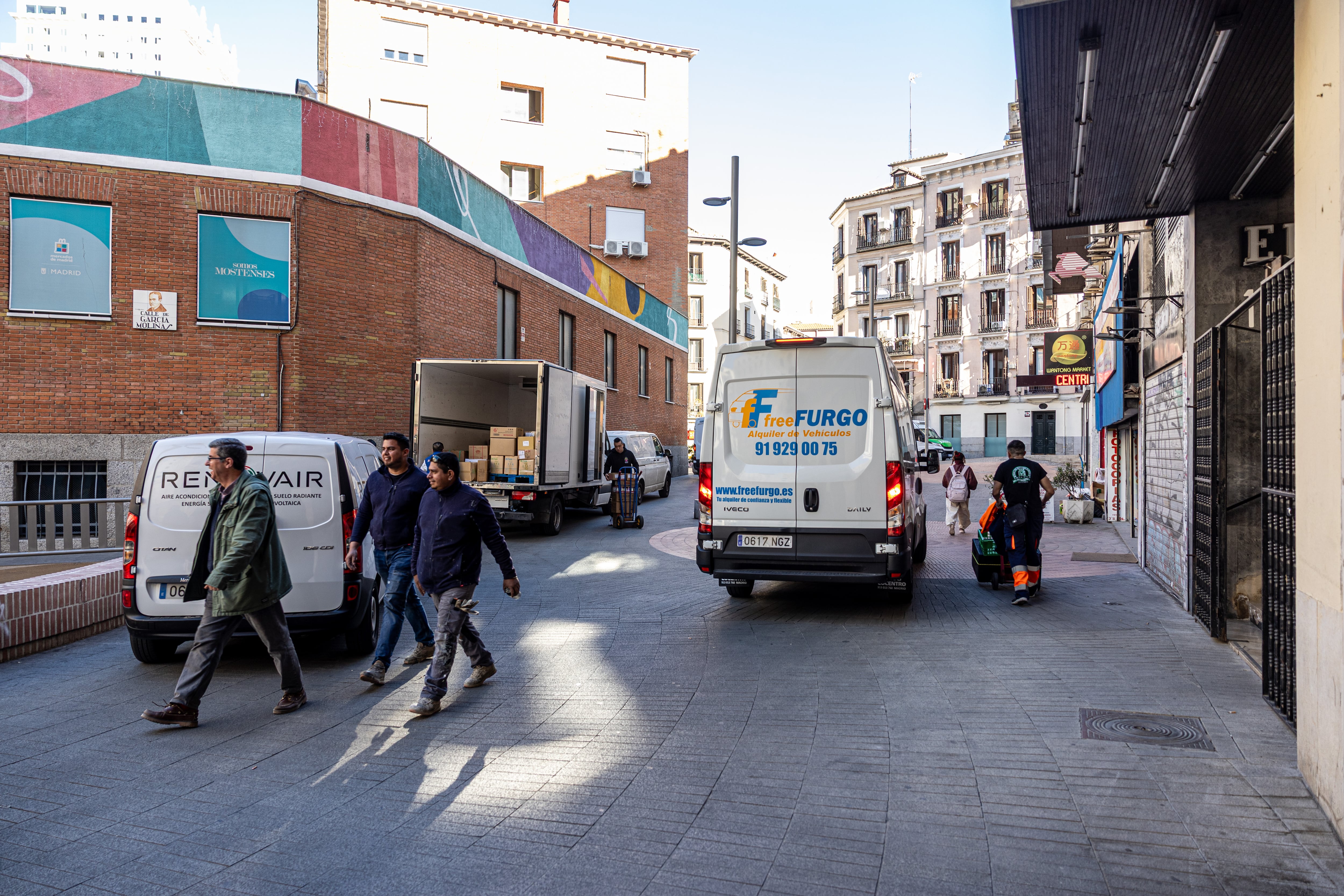 Varios trabajadores descargan cajas de una furgoneta en la plaza de los Mostenses, el pasado 31 de marzo.