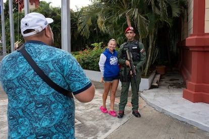 Una turista rusa se fotografía junto a un militar venezolano que hace guardia afuera del mausoleo del expresidente Hugo Chávez, en Caracas. 