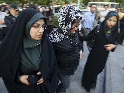 Dos policías escoltan a una joven (centro) hacia una comisaría de Teherán por pintarse y llevar "ropa inadecuada".