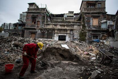 Una persona trabaja cerca de un edificio abandonado y que va a ser demolido, en Shanghai (China).