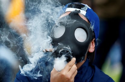 Un hombre fuma marihuana a través de una máscara durante una manifestación por la legalización de la marihuana en Bogotá (Colombia).