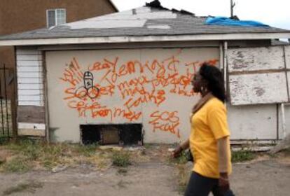 Una mujer pasa frente a una casa abandonada en Richmond.